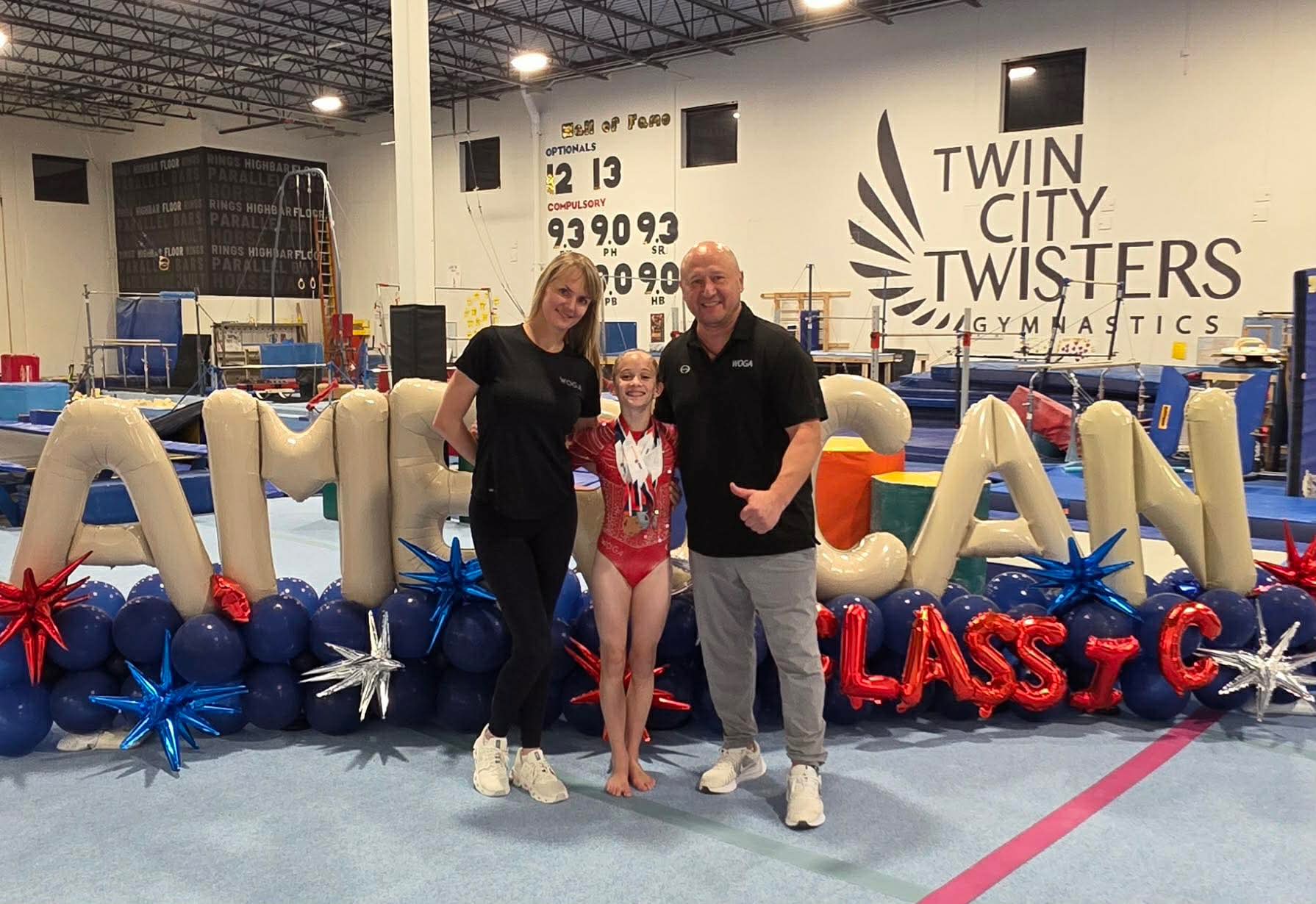 Nora with her WOGA Gymnastics coaches and teammate at the 2025 HOPES Championships